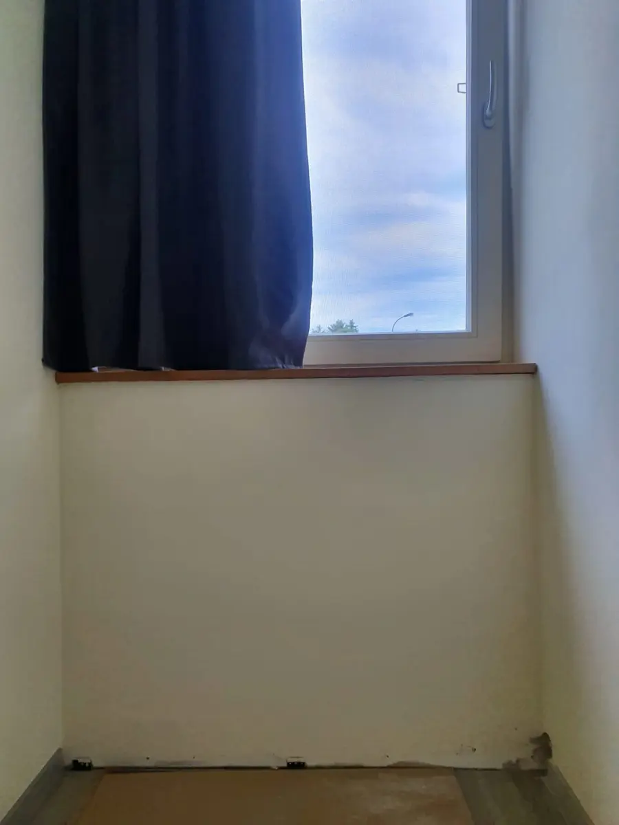 Voor: Lege muur onder een raam voor de plaatsing