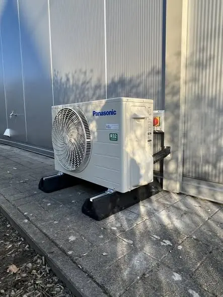 Buitenunit van een Panasonic-warmtepomp aan de gevel